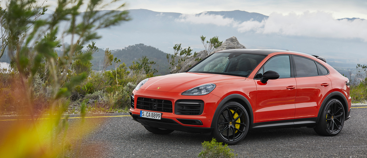 Porsche Cayenne Coupé orange, sur une route de montagne