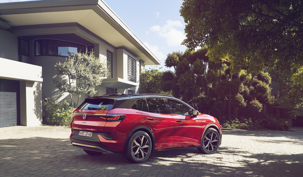 Volkswagen ID4 GTX devant une belle maison sous le soleil