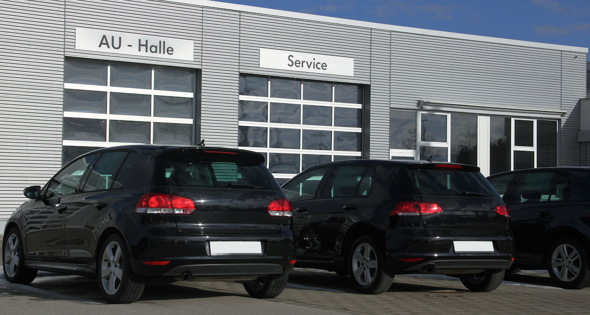 Des Volkswagen Golf noires devant une concession VW et l'atelier de réparation 