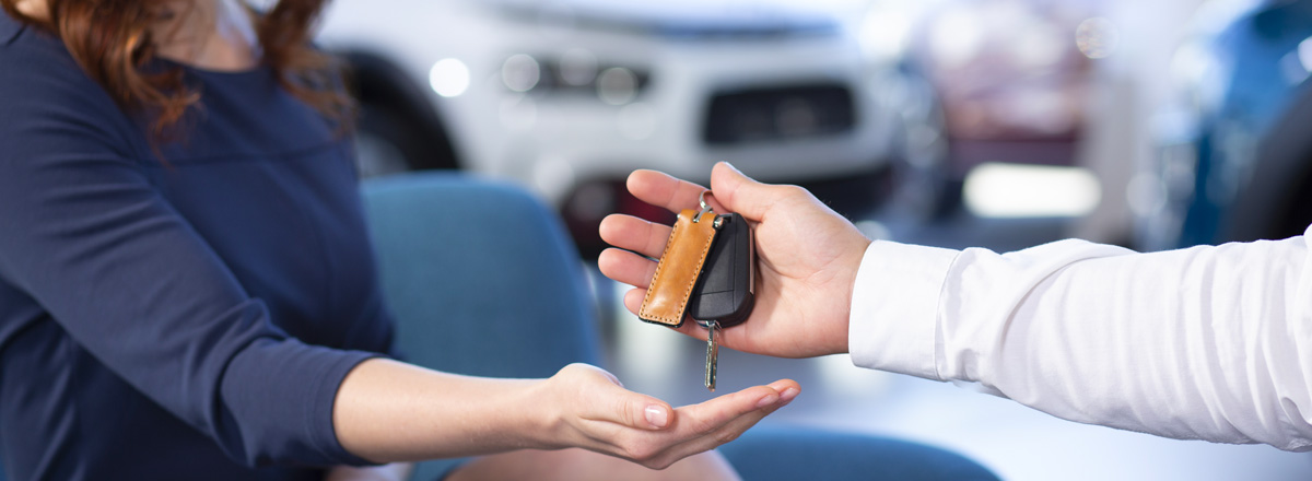 Un mandataire automobile donne les clés d'une voiture à la nouvelle propriétaire 
