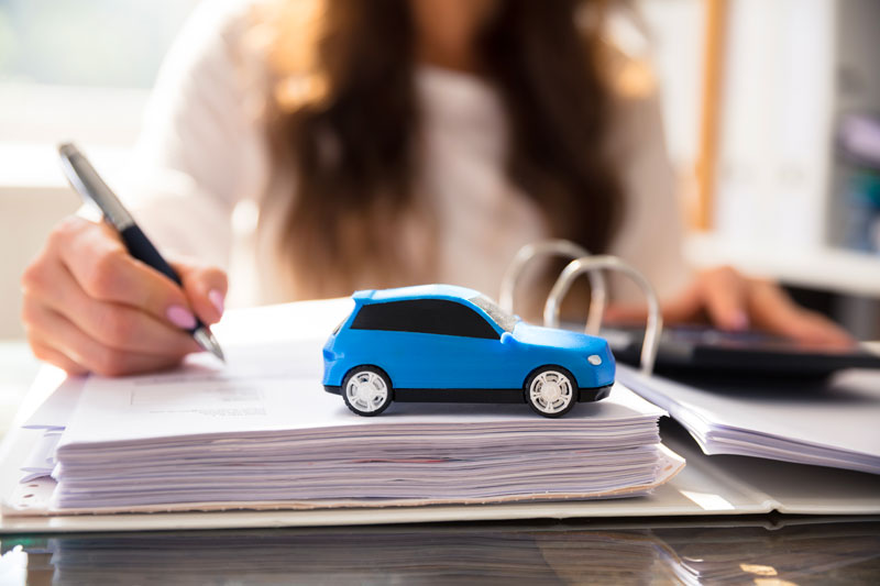 Femme qui signe la facture d'achat de sa nouvelle voiture