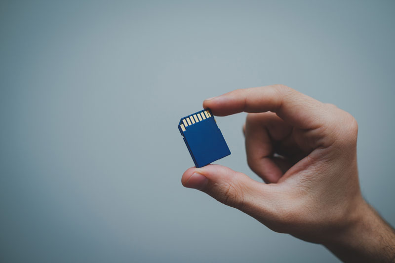 Personne qui tient dans sa main une carte SD