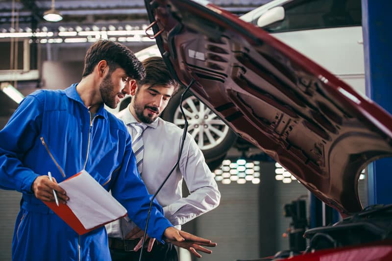 Professionnel qui réalise un contrôle technique sur une voiture