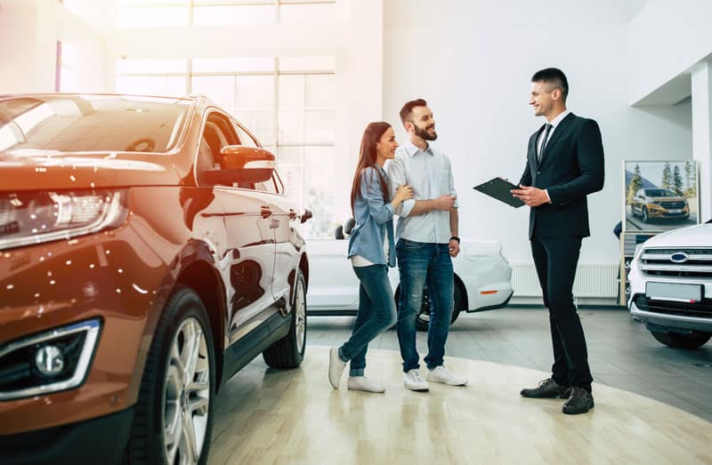 Concessionnaire qui vend une voiture à des clients