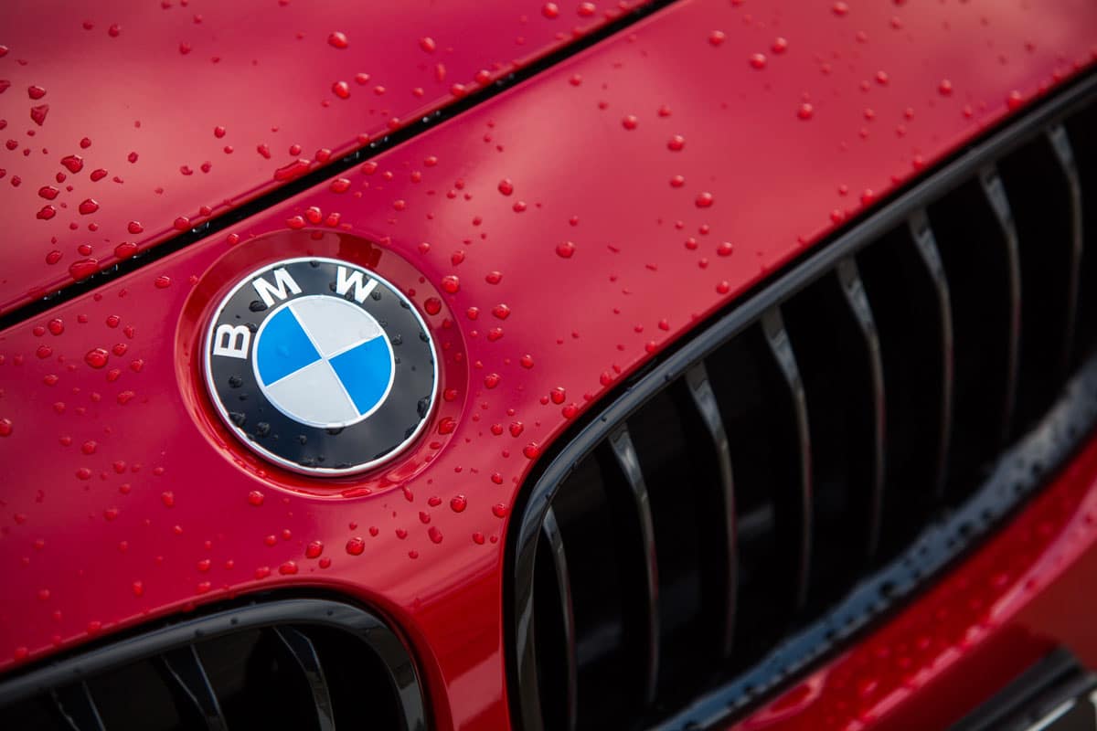 Zoom sur le logo BMW inscrit sur une voiture rouge