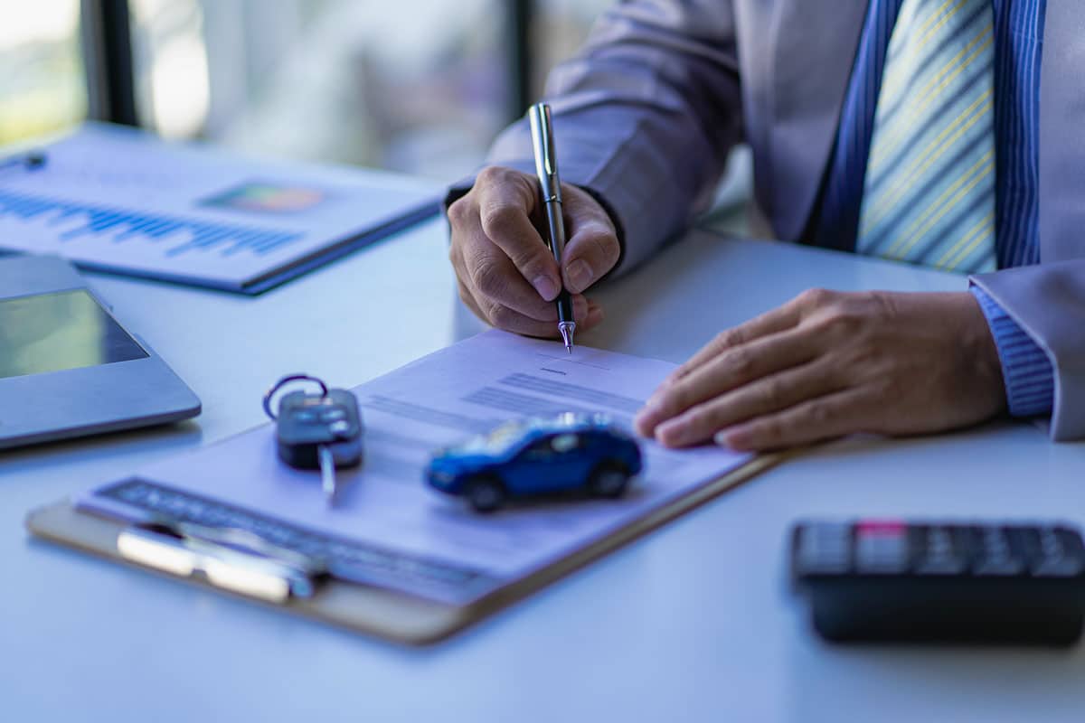 professionnel qui signe un contrat de vente de voiture