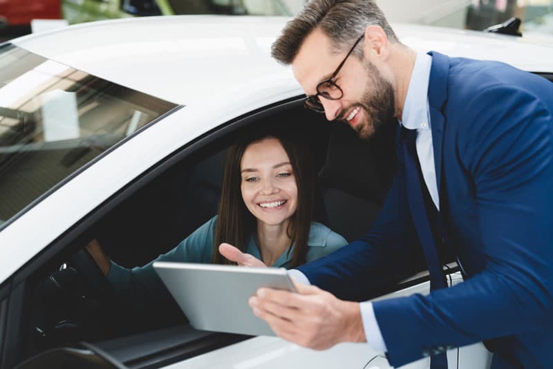 Spécialiste de l'automobile qui présente un véhicule à une conductrice 