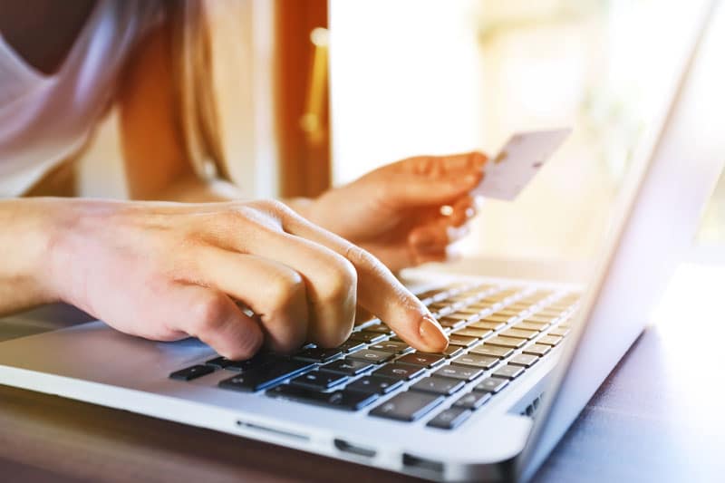Personne qui réalise un paiement avec sa carte bancaire en ligne