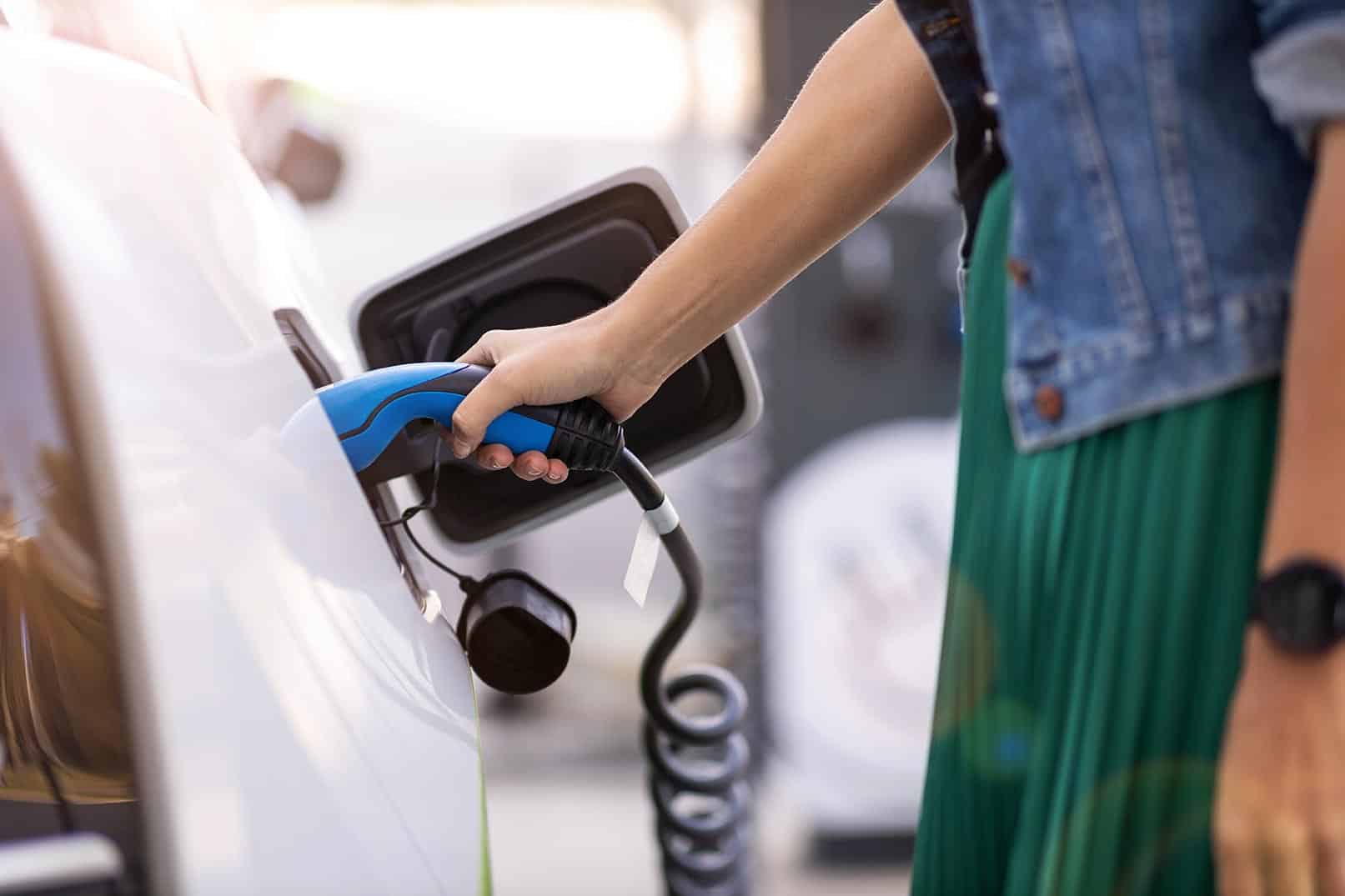 Personne mettant en charge sa voiture électrique.