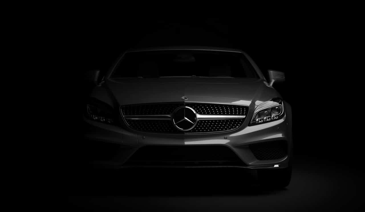 voiture mercedes vue de face, à moitié dans la pénombre.