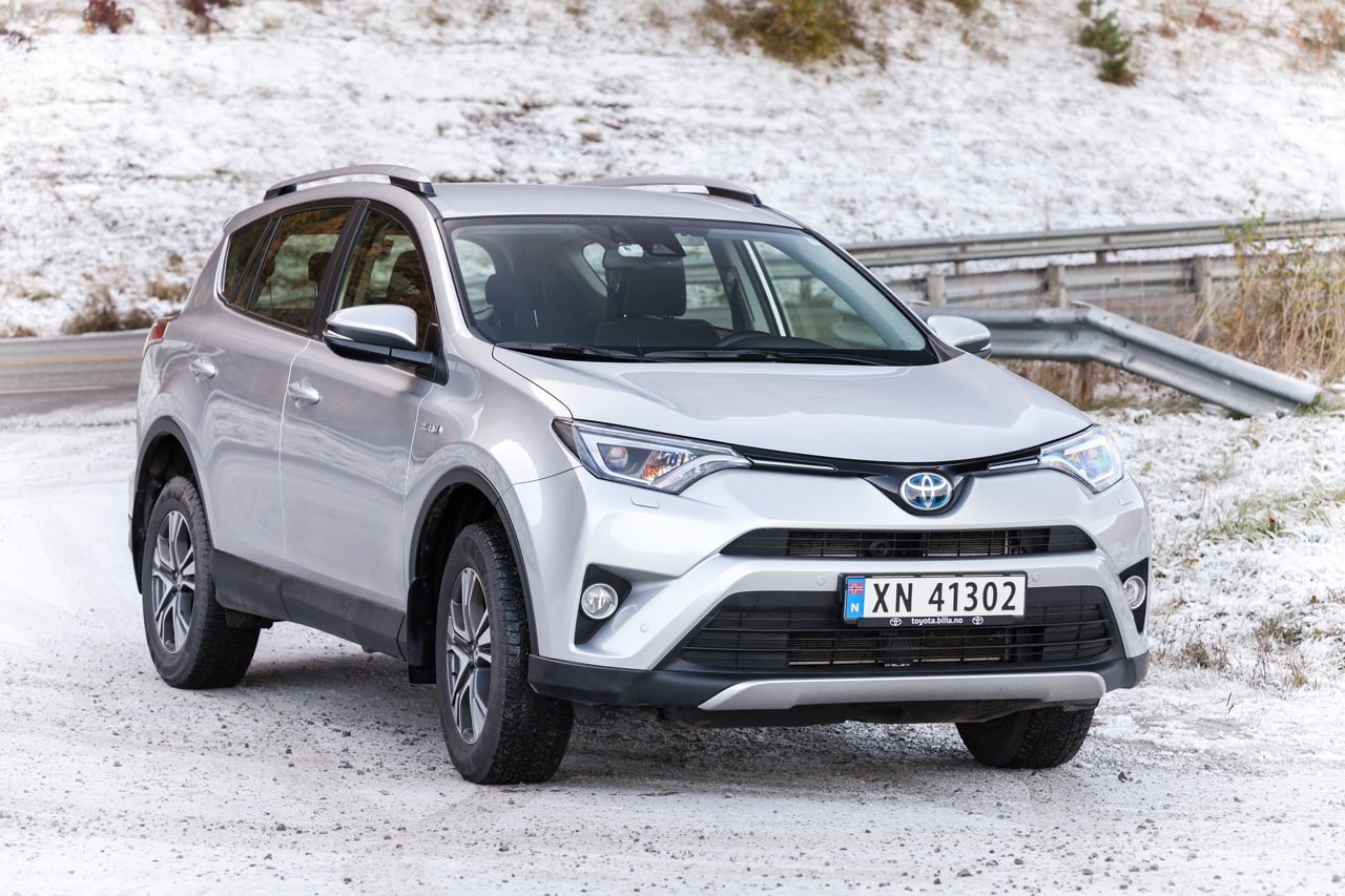 Toyota RAV4 hybride d'occasion, garée le long d'une route enneigée.